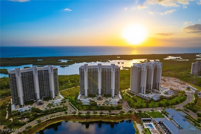 aerial view at dusk featuring a water view