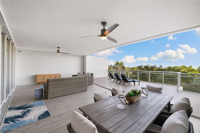 deck with outdoor dining area, ceiling fan, and an outdoor hangout area