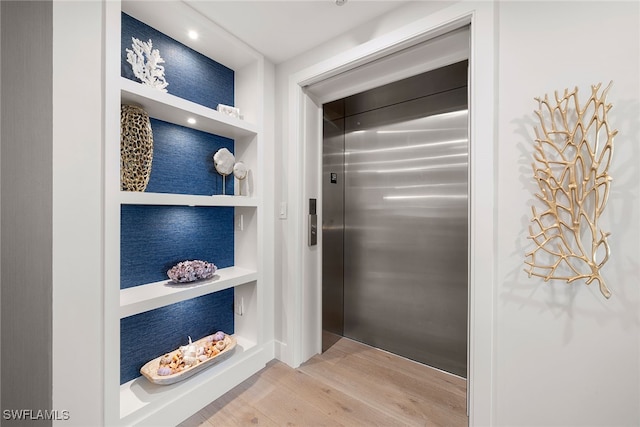 mudroom with hardwood / wood-style flooring and elevator