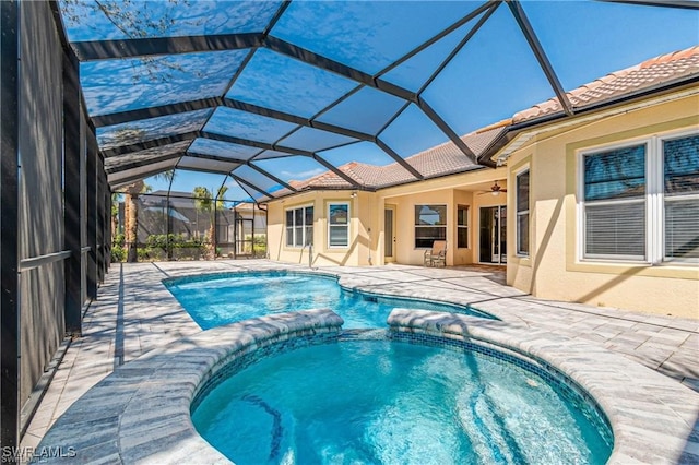 view of swimming pool featuring an in ground hot tub, a patio, glass enclosure, and ceiling fan