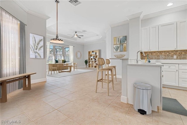 kitchen with ceiling fan, white cabinets, pendant lighting, sink, and tasteful backsplash