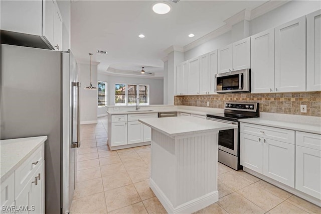 kitchen with white cabinets, sink, kitchen peninsula, tasteful backsplash, and appliances with stainless steel finishes