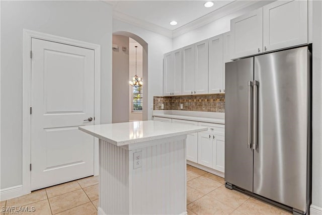 kitchen with light tile patterned floors, a center island, high quality fridge, and white cabinetry