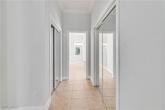 corridor featuring crown molding and light tile patterned floors