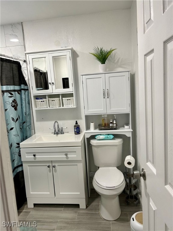 bathroom featuring a shower with shower curtain, hardwood / wood-style flooring, vanity, and toilet