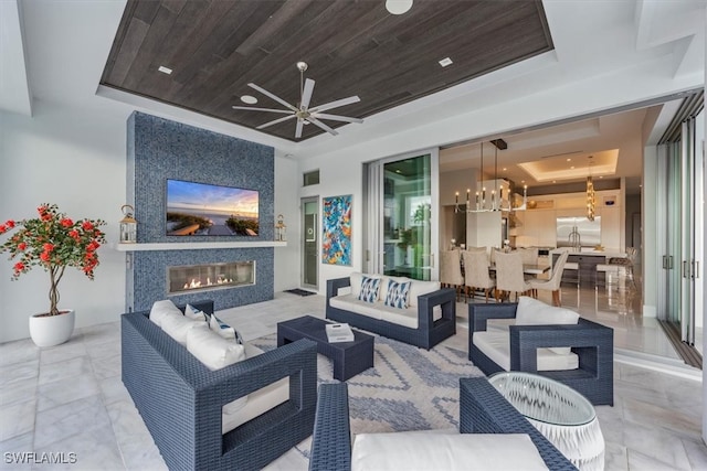 view of patio / terrace with an outdoor living space with a fireplace and ceiling fan