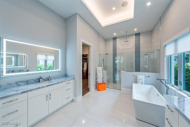 bathroom with tile patterned flooring, separate shower and tub, and vanity