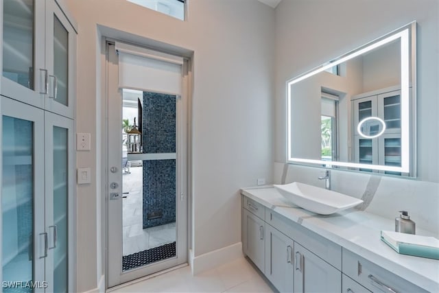 bathroom with tile patterned floors, a healthy amount of sunlight, and vanity