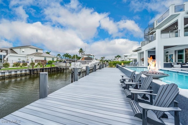 dock area featuring a water view, a patio, and a balcony