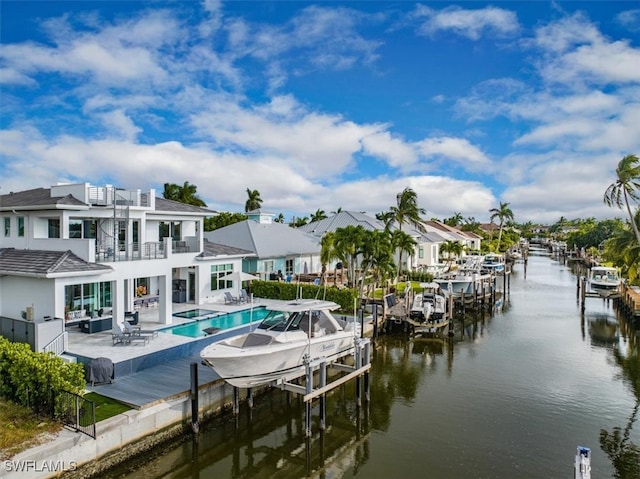 dock area with a water view, a balcony, and a patio area