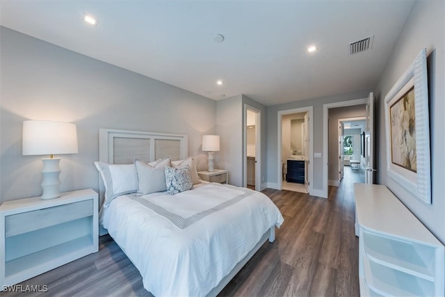 bedroom with connected bathroom and dark hardwood / wood-style floors