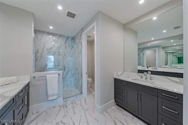 bathroom featuring a tile shower, vanity, and toilet