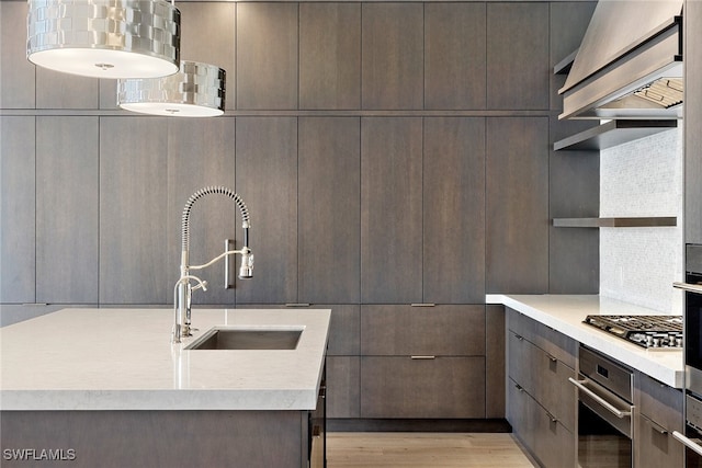 kitchen featuring appliances with stainless steel finishes, sink, light hardwood / wood-style floors, and tasteful backsplash