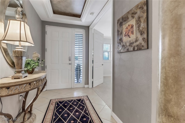 foyer entrance with light tile patterned flooring and a tray ceiling