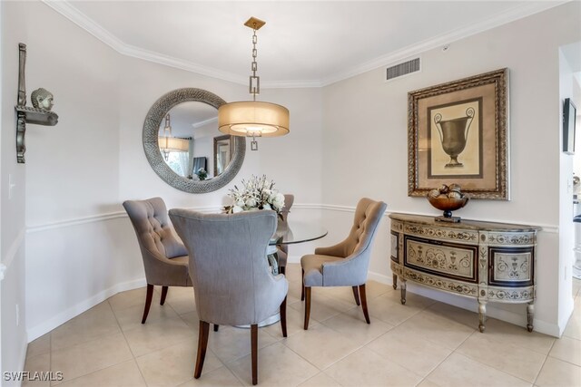 dining area featuring ornamental molding and light tile patterned floors