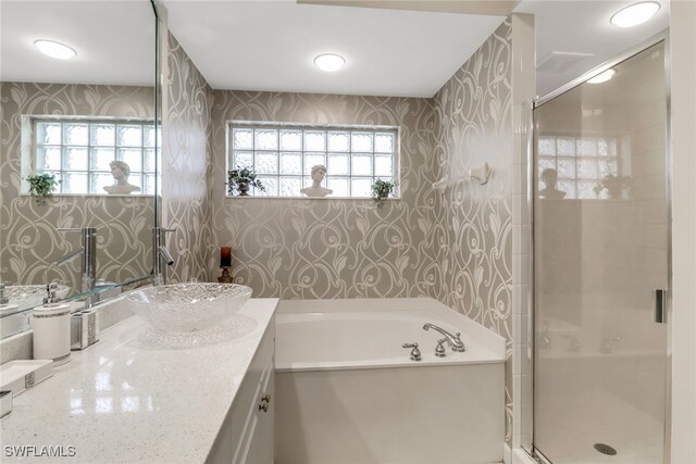 bathroom featuring vanity, plus walk in shower, and plenty of natural light