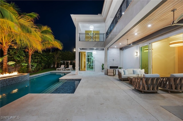 pool at twilight featuring a patio area and an outdoor hangout area