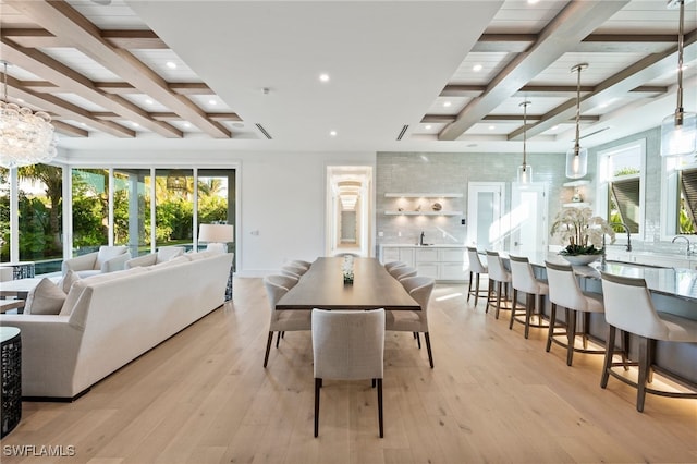 dining area with beam ceiling and light hardwood / wood-style floors