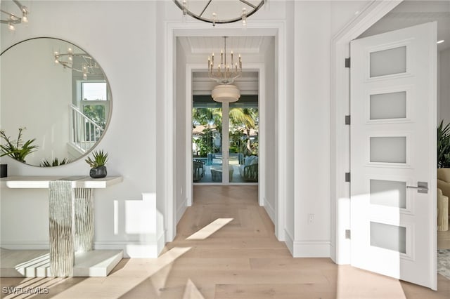 interior space with light hardwood / wood-style flooring, a wealth of natural light, and a notable chandelier