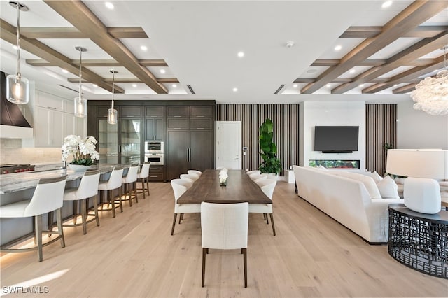 dining area with beam ceiling, coffered ceiling, and light wood-type flooring