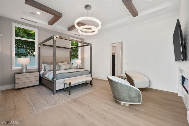 bedroom featuring a chandelier, light hardwood / wood-style flooring, multiple windows, and a high end fireplace