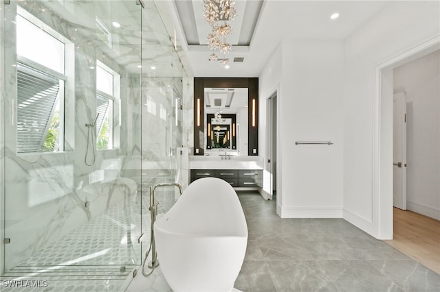 bathroom featuring shower with separate bathtub, vanity, and a notable chandelier