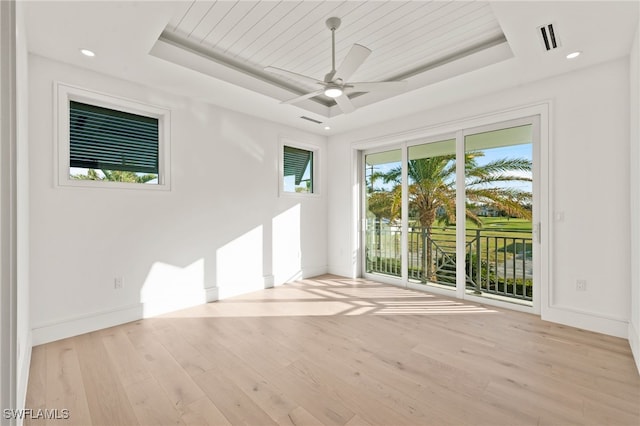 unfurnished room with ceiling fan, wooden ceiling, light hardwood / wood-style flooring, and a tray ceiling