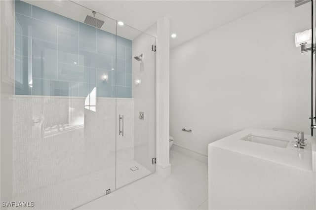 bathroom featuring tile patterned flooring, toilet, a shower with shower door, and sink