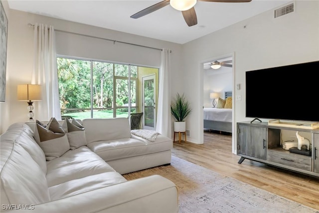 living room featuring light hardwood / wood-style floors and ceiling fan