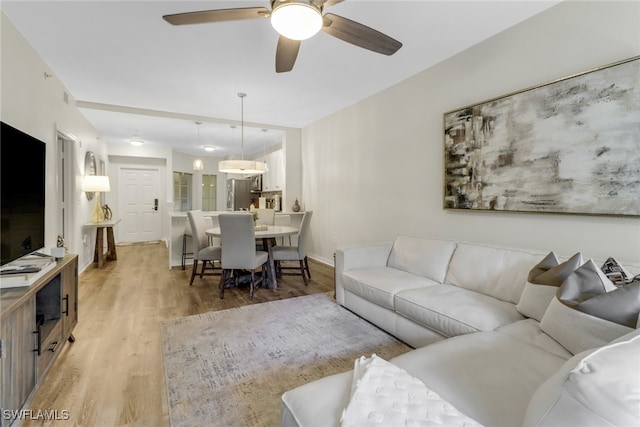 living room featuring ceiling fan and light hardwood / wood-style flooring