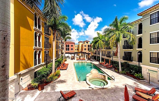 view of pool featuring a hot tub and a patio area