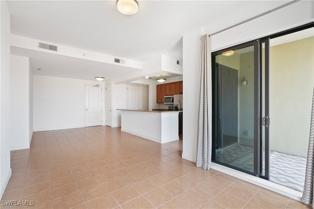 spare room featuring light tile patterned flooring