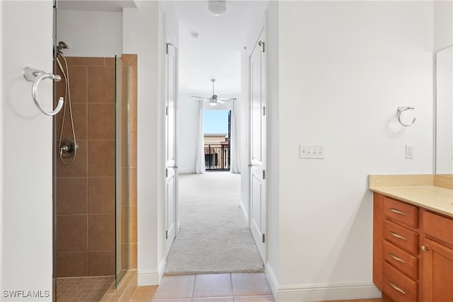 bathroom featuring a shower with door, vanity, ceiling fan, and tile patterned floors