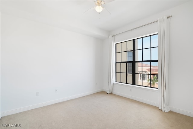 empty room featuring light colored carpet and ceiling fan