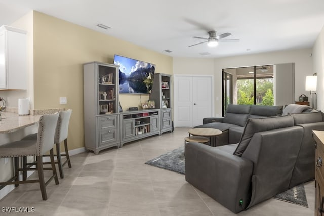 living room featuring light tile patterned floors and ceiling fan