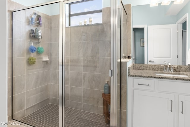 bathroom with a shower with door and vanity