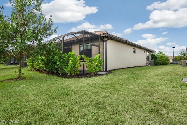 view of home's exterior featuring a lanai and a yard