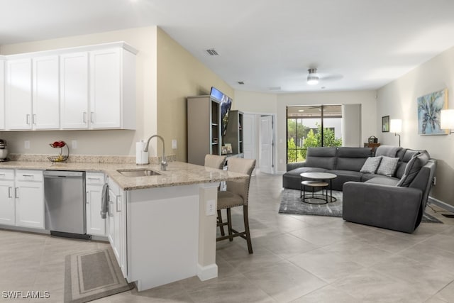 kitchen featuring dishwasher, sink, white cabinetry, ceiling fan, and light stone counters