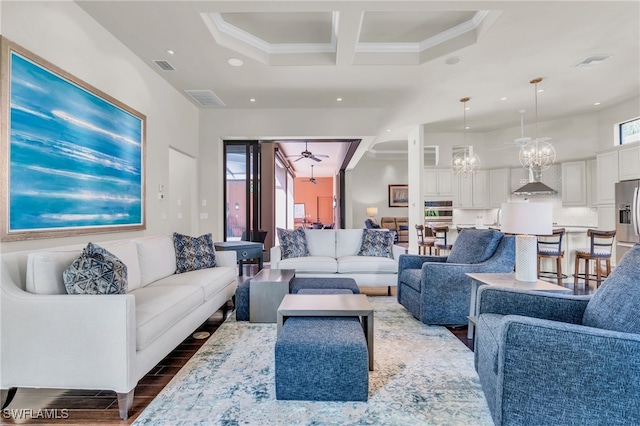 living room with dark hardwood / wood-style floors, a chandelier, and crown molding