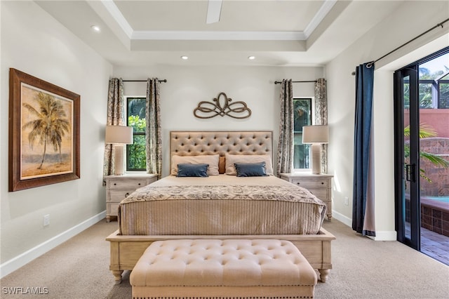 carpeted bedroom featuring a raised ceiling, access to exterior, and multiple windows