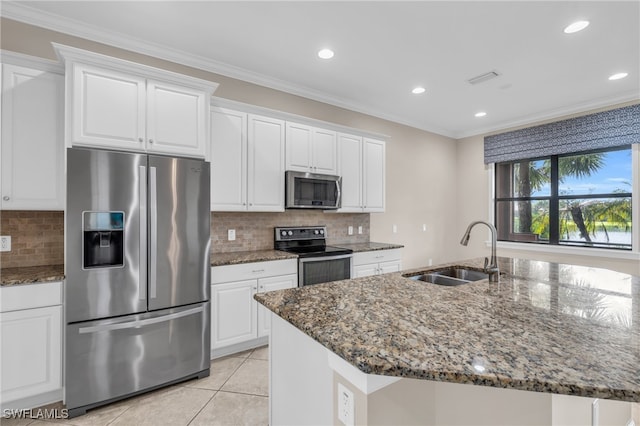 kitchen with appliances with stainless steel finishes, sink, dark stone counters, and white cabinetry