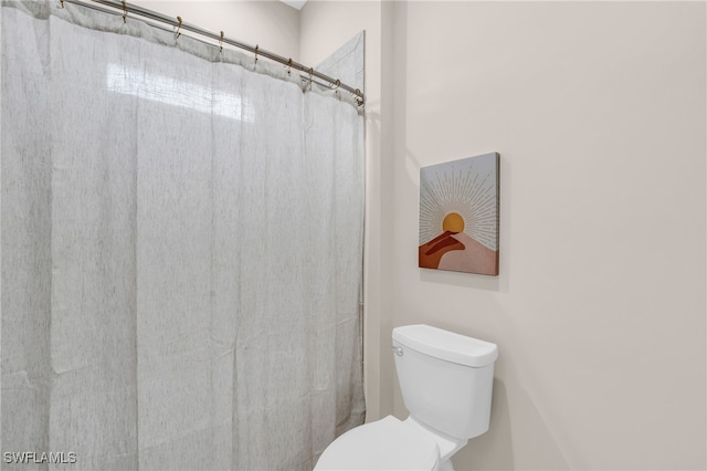 bathroom featuring toilet and a shower with shower curtain