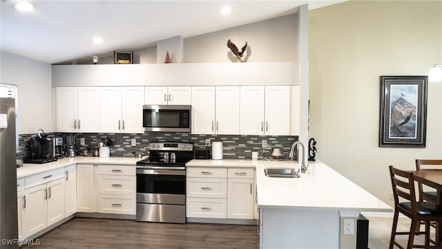 kitchen with white cabinetry, sink, stainless steel appliances, backsplash, and kitchen peninsula