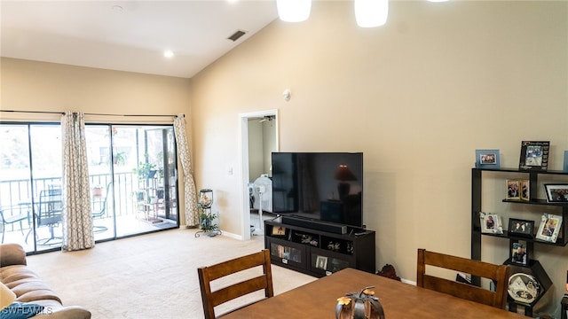 carpeted living room featuring high vaulted ceiling