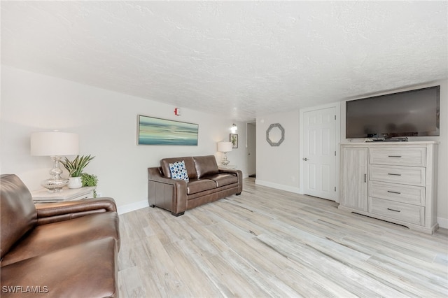 living room featuring a textured ceiling and light hardwood / wood-style floors