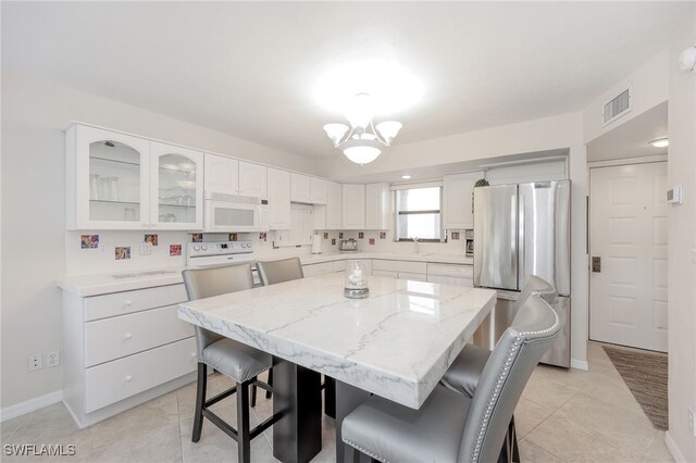 1007 Anglers Cv Unit J204, Marco Island, FL 34145 - dining room featuring baseboards, light tile patterned floors, and a chandelier
