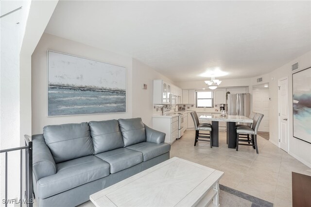 1007 Anglers Cv Unit J204, Marco Island, FL 34145 - living area with a chandelier and light tile patterned floors