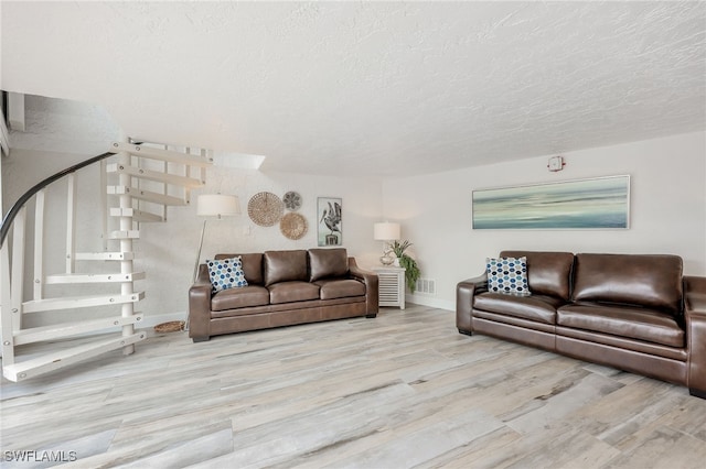 living room with light hardwood / wood-style flooring and a textured ceiling