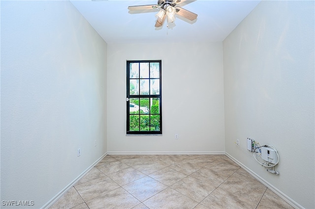 tiled spare room with ceiling fan