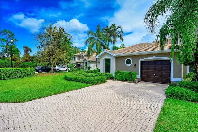 ranch-style house featuring a garage and a front lawn